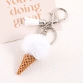 Detailed macro view of plush white fur ball ice cream keychain with silver clasp - White