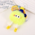 Détail du porte-clés monstre en peluche jaune avec bonnet bleu et breloques - Jaune Néon