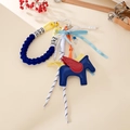Detailed close-up of blue leather Pegasus bag charm with woven rope and heart clasp - Blue
