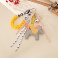 Dettaglio di un ciondolo a cavallo in pelle grigia con ali gialle e perle finte - Corda Intrecciata + Ciondolo Pegaso (K5668) / Giallo
