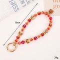 Macro detail of red crystal beaded phone strap with Chinese lion charm and golden clasp - Lion Dance Tunjin Beast Style (K5723醒狮+吞金兽挂件)