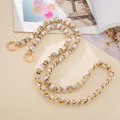 Detailed view of light gold metal chain woven with grey and white plush ribbon strap - Crossbody Chain / Gray
