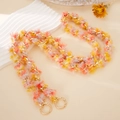 Detail of colorful plush tassels interwoven with a golden metal crossbody chain - Yellow
