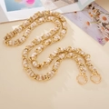 Close-up of golden metal chain interwoven with beige fabric and spring ring clasps - Crossbody Chain / Khaki
