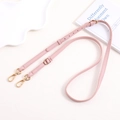 Close-up of pink litchi grain leather strap with adjustable gold metal buckles - Pink