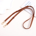 Detail of adjustable brown pebble leather strap with gold lobster clasps and D-ring - Brown