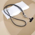 Detalle de cordón para teléfono de pedrería negra con anillo plateado y conector en T - Cadena cruzada / Negro