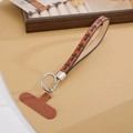 Dettaglio del cinturino da polso in pelle marrone con motivi a croce e anello in metallo - Ciondolo / Motivo a Croce Marrone (K1754)