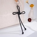 Detail of hand-woven black leather knot bag charm with metallic ring hook for phone or backpack - Black