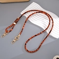 Detail eines verstellbaren Lederriemens mit Leopardenmuster und goldenem Karabiner - Orange (K5793)