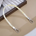 Gros plan de dragonne tressée jaune et blanc avec paillettes argentées et fermoirs mousqueton - Jaune Clair