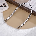Close-up of black and white leopard print PU leather wrist strap with silver metal clasps - White