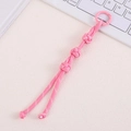 Close-up of pink handmade woven nylon knot charm with circular spring clasp - Pink