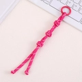 Detailed macro view of a pink nylon paracord bag charm with a round locking buckle - Rose Red