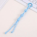 Macro shot of light blue hand-woven nylon cord keychain with round spring buckle - Blue