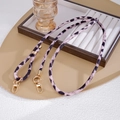 Detail von rosa Leoparden-Plüsch-Handygurt mit goldener Metallschließe auf Tablett - Lila