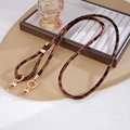 Detailansicht des Plüsch-Lanyards mit Leopardenmuster und goldfarbenen Metallkarabinern - Braun