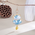 Ciondolo per borsa gatto della fortuna in seta blu con bordo dorato su sfondo decorativo - Blu