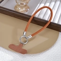 Détail d'une dragonne de téléphone tressée marron avec anneau métallique et connecteur - Marron