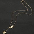 Detailed macro of golden stethoscope and heart pendants on a stainless steel chain - Stethoscope Heart Style / Gold