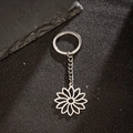 Detail of silver hollow sunflower keychain on a textured black industrial background - Hollow Sunflower Style (167)