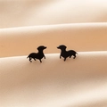 Macro-opname van minimalistische zwarte teckel oorbellen op beige satijnen stof - Teckel Vorm (747) / Zwart