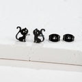 Détail de boucles d'oreilles chat noir minimalistes sur un socle en pierre blanche - Forme de Chat (379) / Noir