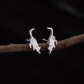 Detalle de pendientes de gato plateados en ramas con textura de metal mate - 793 Gato Gateando Acero