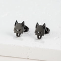 Gros plan de boucles d'oreilles tête de loup noires sur une surface en pierre texturée - Forme Tête de Loup (383) / Noir
