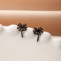Detailed view of matte black dandelion stud earrings on a white ceramic display - Black