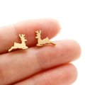 Macro shot of minimalist gold reindeer stud earrings held by hand for scale - Gold