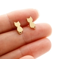 Macro shot of small gold stainless steel cat silhouette studs held by hand for scale - Gold Cat