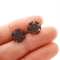 Vista macro de pequeños pendientes de copo de nieve negros con acabado de textura mate - Negro
