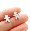Gros plan de petites boucles d'oreilles bonhomme de pain d'épices en acier inoxydable - Acier