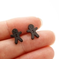 Gros plan de boucles d'oreilles bonhomme de pain d'épices noir mat pour la taille - Noir