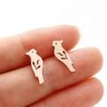 Detailed view of rose gold laser-cut bird stud earrings held for size reference - Bird (373) / Rose Gold