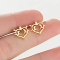 Vue détaillée de boucles d'oreilles cœur dorées avec motifs de volutes ajourés - Or