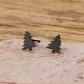 Macro shot of minimalist matte black Christmas tree stud earrings on a textured stone base - Christmas Tree Style (903) / Black