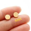 Polished 4mm gold circular stainless steel stud earrings held by fingers for scale - 4mm / Gold
