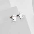 Ohrstecker aus poliertem Edelstahl mit Geist-Motiv auf weißem geometrischem Ständer - Stahlfarben