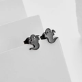Detailansicht der mattschwarzen Geister-Ohrstecker auf weißem geometrischem Hintergrund - Schwarz