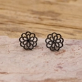 Macro shot of black cutout mandala flower stud earrings with detailed petal layering - Black