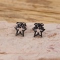 Macro shot of black stainless steel hollow star earrings on a textured stone surface - Star Bow Style (900) / Black