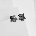 Detail showing creative matte black bat and cat design Halloween earrings on white blocks - Black