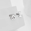 Asymmetric silver cat paw and bone stud earrings on a white minimalist geometric stand - Silver