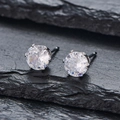 Vue macro de boucles d'oreilles argentées avec zircone ronde sertie de six griffes classiques - Strass Blanc