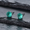Vue macro de boucles d'oreilles en zircone vert émeraude avec serti à quatre griffes - Strass Vert Clair