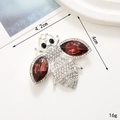 Macro view showing 4.2cm x 4cm rhinestone bee brooch with silver finish and red crystals - Purple Navette Bee