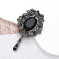 Vintage silver brooch with oval black gemstone and intricate filigree floral design - Gun Black Black Gem (D1341)
