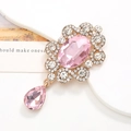 Macro-opname van een vintage hanger met roze kristal en sprankelende kleine diamanten - Legering / Gouden Basis Roze